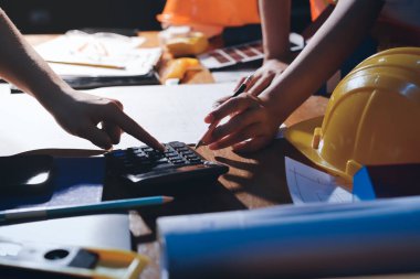 Endüstriyel mühendislerden oluşan bir ekip, fabrikadaki masada bulunan makine planlarını analiz ediyor. Fabrikada ya da üretim tesisinde çalışıyorum..