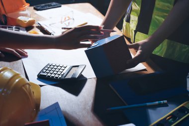 Endüstriyel mühendislerden oluşan bir ekip, fabrikadaki masada bulunan makine planlarını analiz ediyor. Fabrikada ya da üretim tesisinde çalışıyorum..