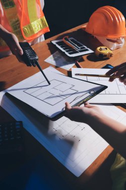 Endüstriyel mühendislerden oluşan bir ekip, fabrikadaki masada bulunan makine planlarını analiz ediyor. Fabrikada ya da üretim tesisinde çalışıyorum..