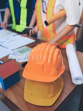 Endüstriyel mühendislerden oluşan bir ekip, fabrikadaki masada bulunan makine planlarını analiz ediyor. Fabrikada ya da üretim tesisinde çalışıyorum..