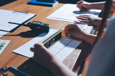 Endüstriyel mühendislerden oluşan bir ekip, fabrikadaki masada bulunan makine planlarını analiz ediyor. Fabrikada ya da üretim tesisinde çalışıyorum..