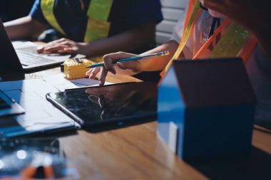 Endüstriyel mühendislerden oluşan bir ekip, fabrikadaki masada bulunan makine planlarını analiz ediyor. Fabrikada ya da üretim tesisinde çalışıyorum..
