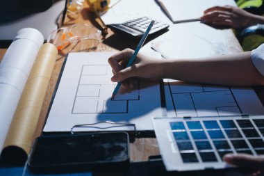 Endüstriyel mühendislerden oluşan bir ekip, fabrikadaki masada bulunan makine planlarını analiz ediyor. Fabrikada ya da üretim tesisinde çalışıyorum..