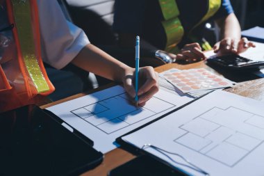 Endüstriyel mühendislerden oluşan bir ekip, fabrikadaki masada bulunan makine planlarını analiz ediyor. Fabrikada ya da üretim tesisinde çalışıyorum..