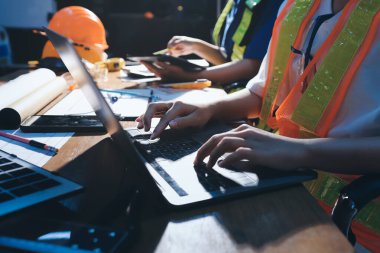 Endüstriyel mühendislerden oluşan bir ekip, fabrikadaki masada bulunan makine planlarını analiz ediyor. Fabrikada ya da üretim tesisinde çalışıyorum..