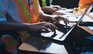 Endüstriyel mühendislerden oluşan bir ekip, fabrikadaki masada bulunan makine planlarını analiz ediyor. Fabrikada ya da üretim tesisinde çalışıyorum..