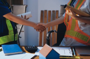 Endüstriyel mühendislerden oluşan bir ekip, fabrikadaki masada bulunan makine planlarını analiz ediyor. Fabrikada ya da üretim tesisinde çalışıyorum..
