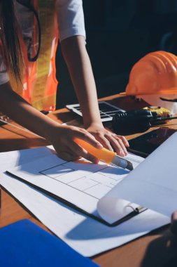 Endüstriyel mühendislerden oluşan bir ekip, fabrikadaki masada bulunan makine planlarını analiz ediyor. Fabrikada ya da üretim tesisinde çalışıyorum..