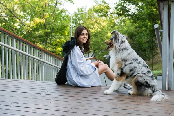 Wanita Muda Yang Duduk Samping Anjing Aussie Nya Taman Blue — Stok Foto