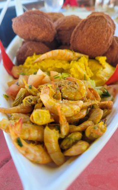 Lezzetli bir karışım içeren canlı bir yemek çeşnili karides ve acaraje denilen afrika yemeği, hepsi beyaz bir tabakta ustalıkla hazırlandı..