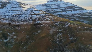 Kışlar Kucaklıyor: Bulutlu Gökyüzünün Altında Dağlık bir Manzara