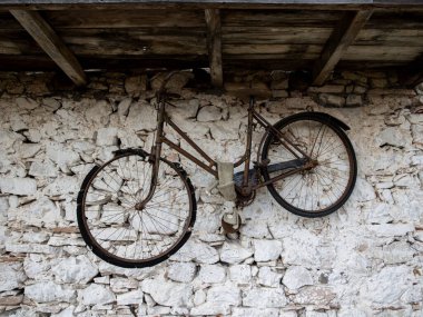 Yıpranmış taş bir duvarda asılı eski bir bisiklet. Yüksek kalite fotoğraf