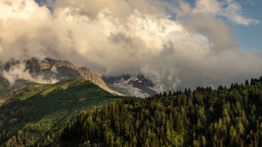 08-24-2021 - Gökyüzü bulutlu Alp dağlarının tepeleri, Fransa 'da yeşil orman Mont Blanc' ın tepesine normal yol