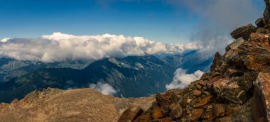 08-25-2021 - Panorama bulutların arkasındaki bulutlar Mont Blanc 'ın altındaki vadiden Fransa' ya normal yoldan zirveye, bulutlar gölgeler