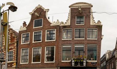 10-03-2024 - Amsterdam, Hollanda - Amsterdam 'daki klasik Hollanda gaçalı evlere yakın çekim, benzersiz cepheler, büyük pencereler ve tarihi şehir mimarisini tanımlayan karmaşık dekoratif unsurlar sergileniyor. Amsterdam, Hollanda ve Avrupa 'da yakalandı.