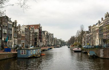 10-03-2024, Amsterdam, Hollanda. Amsterdam, Hollanda 'da, klasik Hollanda mimarisi, bisikletleri, yayalar ve kentsel cazibeyle çevrili çarpıcı, dar, hafif eğimli bir kanal evi..