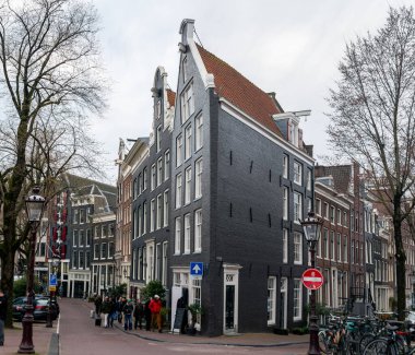 10-03-2024, Amsterdam, Hollanda. Amsterdam, Hollanda 'da, klasik Hollanda mimarisi, bisikletleri, yayalar ve kentsel cazibeyle çevrili çarpıcı, dar, hafif eğimli bir kanal evi..