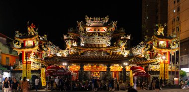 14-08-2023 - Taipei, Thaiwan: Gece gökyüzünün altında parlayan muhteşem tapınak, ziyaretçilerin yiyecek tezgahlarını, yerel zanaatları ve kentsel çevredeki kültürel gösterileri keşfettiği canlı gece pazarıyla çevrili. Tayvan, Asya 'da yakalanmış..