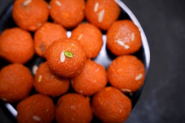 Geleneksel Hint tatlı Laddu 'sunun kapağı siyah bir kasede servis edilir.