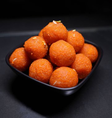 Geleneksel Hint tatlı Laddu 'sunun kapağı siyah bir kasede servis edilir.