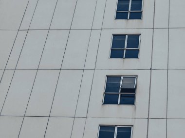 Pencereler ve Geometrik Desenlerle Gri Bina Cephesi