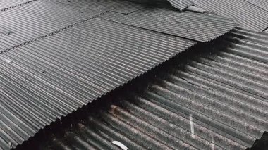 Metal tabakaların desenlerini ve dokusunu gösteren kıvrımlı metal çatının yüksek açılı yakın çekim görüntüsü..