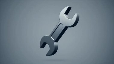 Metalik ingiliz anahtarının detaylı bir görüntüsü, yaygın bir alet, sessiz gri bir arka plana karşı havada asılı duruyor..