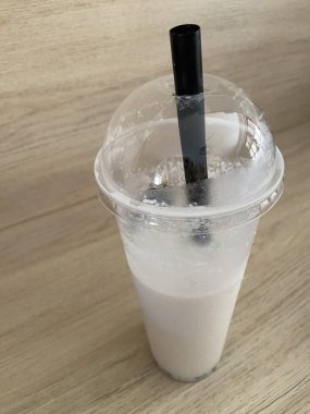 Ahşap zemin üzerinde buzlu hindistan cevizi ve süt suyu.