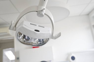Modern bir dişçi kliniğinde, parlak tasarımı ve aydınlatması ile dişçi aydınlatmasının yakın plan görüntüsü..