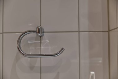 Krom havlu tutacağının karo bir duvara monte edilmiş yakın çekim görüntüsü. Tutucu parlak bir kaplaması olan parlak, modern bir tasarıma sahiptir, ışığı yansıtır..