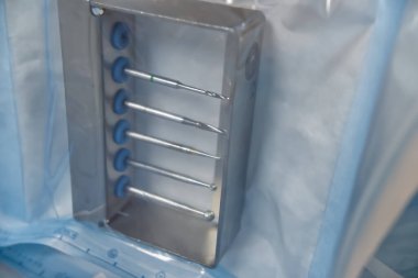 Beş dikey çubuklu paslanmaz çelik bir kalıp, temiz bir plastik torbaya yerleştirilmiş. Küf, bir süreç sırasında maddeleri yerinde tutmak veya şekillendirmek için tasarlanmıştır..