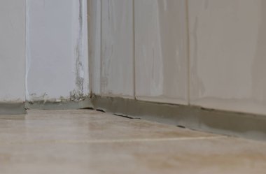 Döşeme ve duvar köşelerinin yakın görüntüsü, sergilenen harç hatları ve fayans kenarları. Yüzey hafif bir parıltıyla temiz görünüyor. Fayansların kesişimini vurguluyor..