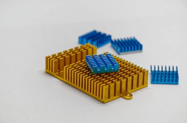 Altın ve mavi bilgisayar ısı kümesi, açık arkaplanda altın ve mavi de dahil olmak üzere çeşitli renklerde batar. Isı alıcıları elektronik bileşenleri soğutmak için tasarlanmıştır..