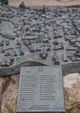 Kappeln 'de binalar, sokaklar ve yel değirmeninin yer aldığı tarihi bir kasaba planını gösteren bronz bir yardım haritası. Rahatlamanın dokusu ve derinliği mimari detayları vurguluyor..
