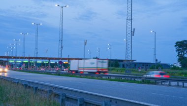 Danimarka 'da Korsor yakınlarındaki Öresund Oeresund Köprüsü' ndeki gişe bariyerleri. Alacakaranlıkta araba ve trafik ışıklarıyla Büyük Kemer 'i geçiyor.