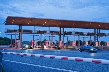 Danimarka 'nın Korsor Kursoer kentinin doğu yakasındaki Öresund Oeresund Köprüsü' ndeki gişe bariyerlerinde alacakaranlıkta kırmızı ve beyaz bir bariyer var.