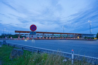 Danimarka 'da Korsor yakınlarındaki Öresund Oeresund Köprüsü' ndeki gişe bariyerleri. Alacakaranlıkta araba ve trafik ışıklarıyla Büyük Kemer 'i geçiyor.