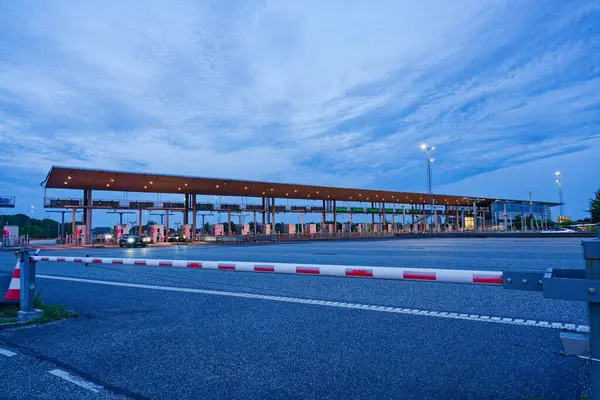 Danimarka 'nın Korsor Kursoer kentinin doğu yakasındaki Öresund Oeresund Köprüsü' ndeki gişe bariyerlerinin önünde alacakaranlıkta kırmızı ve beyaz bir bariyer bulunuyor.