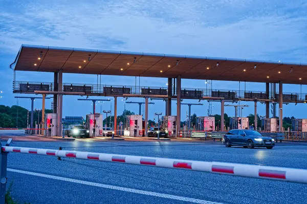 Danimarka 'nın Korsor Kursoer kentinin doğu yakasındaki Öresund Oeresund Köprüsü' ndeki gişe bariyerlerinde alacakaranlıkta kırmızı ve beyaz bir bariyer var.