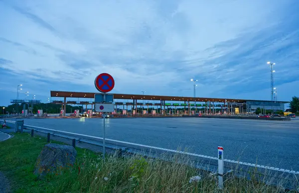 Danimarka 'da Korsor yakınlarındaki Öresund Oeresund Köprüsü' ndeki gişe bariyerleri. Alacakaranlıkta araba ve trafik ışıklarıyla Büyük Kemer 'i geçiyor.
