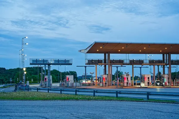 Danimarka 'da Korsor yakınlarındaki Öresund Oeresund Köprüsü' ndeki gişe bariyerleri. Alacakaranlıkta araba ve trafik ışıklarıyla Büyük Kemer 'i geçiyor.