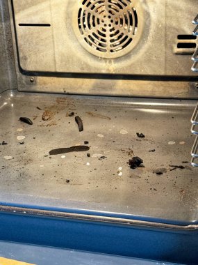 Bir fırının zemininde kömürleşmiş yemek hazırlama kalıntıları vardır. cips ve diğer yiyecekler