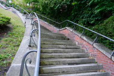 Yeşillik yeşil parktaki metal korkuluklu eğri taş merdiven Flensburg Sarayı 'na çıkıyor.