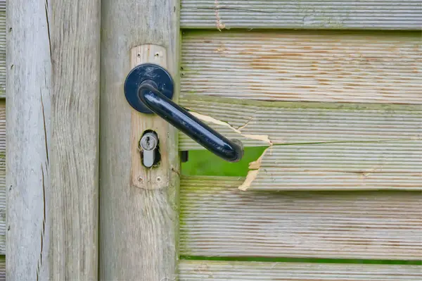 Dışarıdaki eski ahşap kapı. Orta kiriş kilidi kırık. Anahtar deliği var.