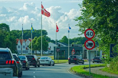 Krusau Krusa Harrislee 'de, Danimarka ile Almanya arasındaki sınır kapısı. Bayrakları ve arabaları var. Gökyüzü bulutlu.