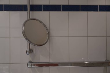 Alternatif açı modern erişilebilir duşu gösteriyor sağ yatay ayna, yatay ve dikey kavrama çubukları beyaz fayanslara karşı mavi aksanlı şeritler, işlevsel banyo tasarımı