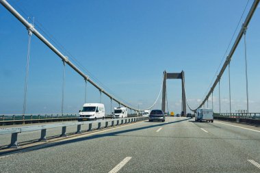 Kablolu bir köprü manzarası yollarda araçlar, açık mavi gökyüzü