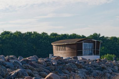 Yakınlarda büyük taşları olan gemi şeklinde eşsiz ahşap bir ev. Kıvrımlı bir güverte, küçük pencereler ve gemi yayı gibi görünen bir balkon, görünüş gibi büyüleyici bir gemi yaratıyor..