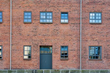 Katı kırmızı tuğla bir yapı, her iki katta da parlak siyah çerçeveli plastik pencereler ve aynı siyah kapılara sahiptir. Tasarım, Kopenhag CPH 'de minimalist ve endüstriyel.