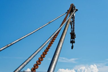 Kopenhag CPH 'ın sonunda sağlam bir kanca asılı ağır, paslı bir zincir içeren, açık mavi bir gökyüzüne karşı duran büyük metal bir vinç.